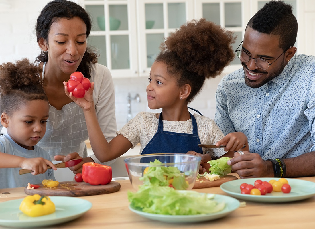 Personal Insurance - Happy Family Preparing Salad Together in a Kitchen